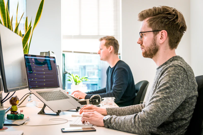 Twee ontwikkelaars aan het werk in een licht kantoor