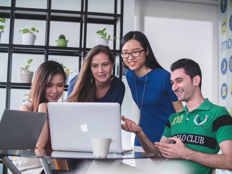 Vier collega’s bespreken een ontwerp op een laptop